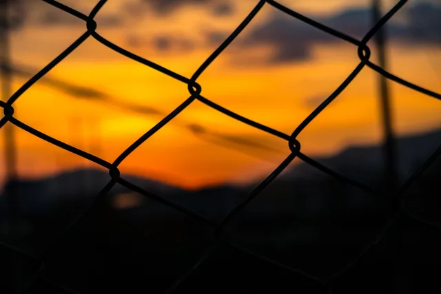 sunset, fence, chain link, chain-link fence, nature, wire fence, woven fence, dusk, silhouette, dark, closeup. What to put in a fence contractor business package for 2027