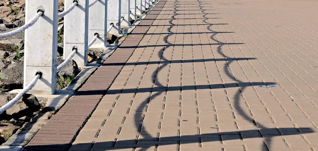 railing, fence, shadows, rope, concrete post. How Canadian fence contractors build quotes around provincial building codes