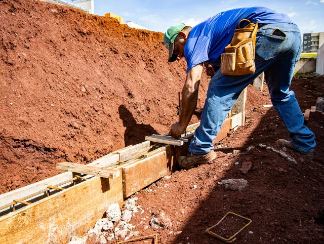 Male construction worker building a foundation outdoors in Londrina, Brazil. Fence contractor services and packages guide for 2027