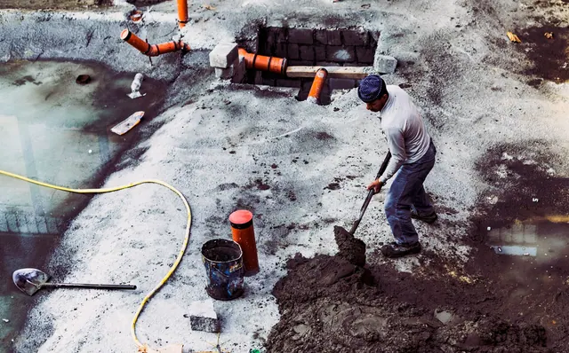 A male construction worker shoveling soil at an outdoor building site in Dubai, UAE. Most profitable fence contractor services